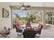 Covered patio with cozy seating area overlooking the pool and tropical landscape at 5412 Royal Poinciana Way, North Port, FL 34291