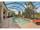 Screened-in pool with paved deck and lush tropical landscaping at 5412 Royal Poinciana Way, North Port, FL 34291