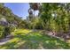Expansive, well-maintained backyard with lush green grass and mature trees providing shade and privacy at 5712 Garden Lakes Fern, Bradenton, FL 34203