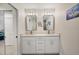 Modern bathroom featuring double sinks, stone countertops, decorative lighting, and a glass shower enclosure at 5712 Garden Lakes Fern, Bradenton, FL 34203