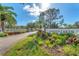 Welcoming entrance to Garden Lakes, featuring lush landscaping, a sign, and a glimpse of the charming community beyond at 5712 Garden Lakes Fern, Bradenton, FL 34203