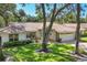 Well-kept home with a tile roof, manicured lawn, and mature trees, offering a tranquil and inviting curb appeal at 5712 Garden Lakes Fern, Bradenton, FL 34203