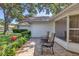 Charming front patio featuring brick paving, lush landscaping, and comfortable seating under a shady tree at 5712 Garden Lakes Fern, Bradenton, FL 34203