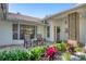 Inviting front porch with brick accents, tiled roof, and beautiful landscaping for outdoor seating at 5712 Garden Lakes Fern, Bradenton, FL 34203