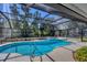 Beautiful screened-in pool with spa, nestled among lush greenery, offering a tranquil outdoor living space at 5712 Garden Lakes Fern, Bradenton, FL 34203