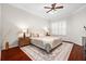 Cozy bedroom features an upholstered bed, wood floors, and a stylish ceiling fan at 5907 90Th Avenue E Cir, Parrish, FL 34219