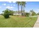 Beautifully landscaped home exterior featuring lush green grass, mature trees, and meticulous shrubbery at 5907 90Th Avenue E Cir, Parrish, FL 34219