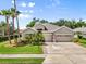 Charming home showcasing a well-manicured lawn, lush landscaping, and a welcoming three-car garage on a beautiful day at 5907 90Th Avenue E Cir, Parrish, FL 34219