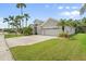 Inviting home exterior with a well-manicured lawn, mature palm trees, and a welcoming three-car garage at 5907 90Th Avenue E Cir, Parrish, FL 34219