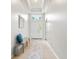 Bright hallway with a bench, mirror, and view of the front door with transom window at 5907 90Th Avenue E Cir, Parrish, FL 34219