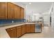 Open kitchen with stainless steel appliances, wood cabinets, and a view to the living room at 5907 90Th Avenue E Cir, Parrish, FL 34219