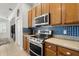 Contemporary kitchen featuring stainless steel appliances, tiled backsplash, and wood cabinets at 5907 90Th Avenue E Cir, Parrish, FL 34219