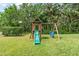 Lush backyard featuring a playset with a slide and swings for outdoor fun at 5907 90Th Avenue E Cir, Parrish, FL 34219