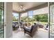 Inviting screened porch with wicker furniture, a ceiling fan, and views of the lush backyard at 5907 90Th Avenue E Cir, Parrish, FL 34219