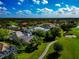 Elevated view of a home near a golf course, enhanced by mature trees and manicured grounds, creating a serene and inviting atmosphere at 600 Eagle Watch Ln, Osprey, FL 34229