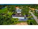 Aerial shot of a blue house showcasing well-manicured landscaping and a paver driveway at 600 Eagle Watch Ln, Osprey, FL 34229
