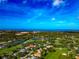 Expansive aerial shot of a verdant golf course community featuring picturesque homes and a stunning coastal backdrop under a clear blue sky at 600 Eagle Watch Ln, Osprey, FL 34229