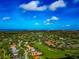 Scenic aerial view of a vibrant golf course community showcasing charming homes, manicured lawns, and a picturesque coastal skyline at 600 Eagle Watch Ln, Osprey, FL 34229