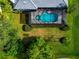 Overhead view of the pool in a screened enclosure, surrounded by lush landscaping at 600 Eagle Watch Ln, Osprey, FL 34229