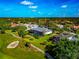 Stunning aerial view of home, golf course, screened pool, and lush tropical landscaping at 600 Eagle Watch Ln, Osprey, FL 34229