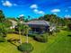 Aerial view of the pool in a screened enclosure, surrounded by lush landscaping at 600 Eagle Watch Ln, Osprey, FL 34229