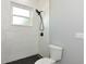 Bathroom shower featuring sleek black fixtures and textured white tile walls at 600 Eagle Watch Ln, Osprey, FL 34229