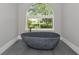 Bathroom showcases a gray standalone tub beside a window with a view of greenery at 600 Eagle Watch Ln, Osprey, FL 34229