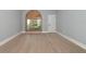 Bright bedroom with natural light, hardwood floors, and arched shuttered window at 600 Eagle Watch Ln, Osprey, FL 34229