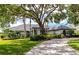 Beautiful single-story home with lush landscaping, mature shade trees, and a circular driveway at 600 Eagle Watch Ln, Osprey, FL 34229