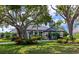 Elegant home with lush landscaping, mature trees, and a well-manicured lawn creating a picturesque curb appeal at 600 Eagle Watch Ln, Osprey, FL 34229
