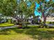 Charming home with black and white trim, arched windows, lush landscaping and mature trees at 600 Eagle Watch Ln, Osprey, FL 34229