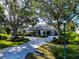 Lovely home featuring a circular driveway, two-car garage, manicured landscaping, and mature trees at 600 Eagle Watch Ln, Osprey, FL 34229