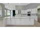 Spacious kitchen with white cabinetry, stainless steel appliances, and large center island at 600 Eagle Watch Ln, Osprey, FL 34229
