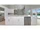 Kitchen island featuring a sink and dishwasher with view of outdoor pool area at 600 Eagle Watch Ln, Osprey, FL 34229