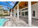 Expansive covered outdoor patio with ceiling fans, columns, and views of the pool, offering a great space for relaxation at 600 Eagle Watch Ln, Osprey, FL 34229