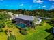 Aerial view of the screened pool area surrounded by lush tropical landscaping at 600 Eagle Watch Ln, Osprey, FL 34229
