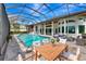 The screened-in outdoor pool area features a spa and stylish patio furniture for relaxing and entertaining at 600 Eagle Watch Ln, Osprey, FL 34229
