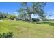 Sprawling front yard with mature trees, lush grass, and a charming home at 6540 Prairie Junction Trl, Sarasota, FL 34241