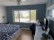 Bright bedroom featuring plank accent wall and large window with view of palm trees at 6703 Midnight Pass Rd # 206, Sarasota, FL 34242