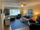 Cozy living room with comfortable seating, a large television, and a ceiling fan at 6703 Midnight Pass Rd # 206, Sarasota, FL 34242