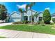 Charming single-story home with a well-manicured lawn, colorful flowerbeds, and lush palm trees at 736 Rosemary Cir, Bradenton, FL 34212