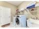 Bright laundry room with a modern washer, dryer, shelving, and a utility sink at 736 Rosemary Cir, Bradenton, FL 34212