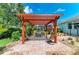 Backyard pergola over brick paver patio featuring an outdoor seating area and well-manicured landscaping at 736 Rosemary Cir, Bradenton, FL 34212