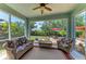 Relaxing screened porch with cozy seating, a ceiling fan, and views of the landscaped backyard at 736 Rosemary Cir, Bradenton, FL 34212