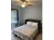 Cozy bedroom featuring a ceiling fan and a comfortable-looking murphy bed with stylish bedding at 7508 Mikasa Dr, Punta Gorda, FL 33950