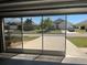 View from the garage with screened doors to the exterior of the home, showing the driveway and house across the street at 7508 Mikasa Dr, Punta Gorda, FL 33950