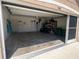 Spacious garage with an open door, with storage and equipment along the walls, and a side entrance door at 7508 Mikasa Dr, Punta Gorda, FL 33950