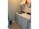 Well-lit laundry room with white washer and dryer, and shelving for storage at 7508 Mikasa Dr, Punta Gorda, FL 33950