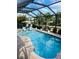 Inviting screened-in pool with lounge seating and lush landscaping, perfect for relaxing and entertaining outdoors at 7508 Mikasa Dr, Punta Gorda, FL 33950