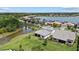 Aerial view of home with a gray roof, a pond, and a view of a lake and surrounding neighborhood at 7765 Grande Shores Dr, Sarasota, FL 34240